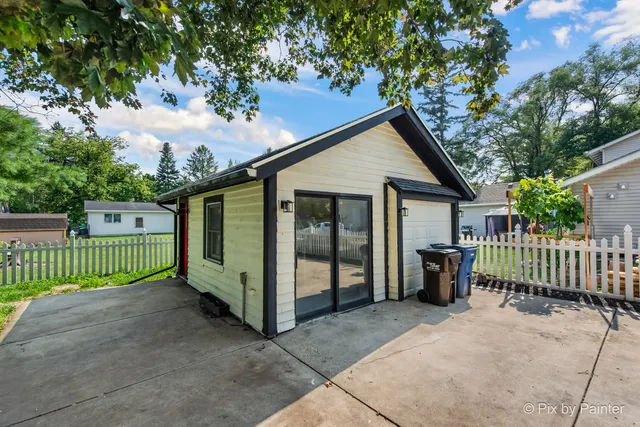 a view of a house with a small yard plants and large tree