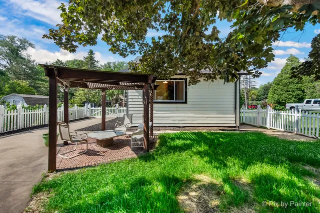 a view of a backyard with wooden fence and a large tree