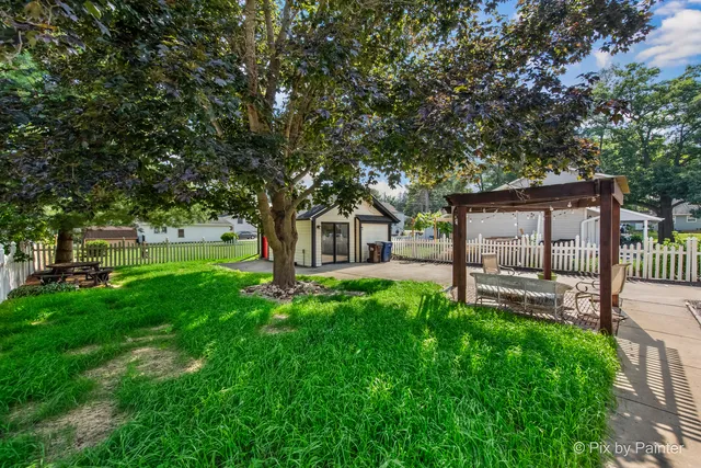 a view of a house with backyard and a tree