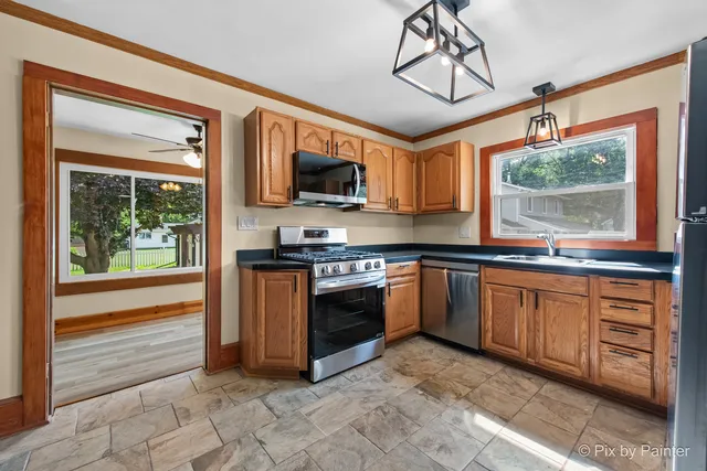 a kitchen with stainless steel appliances granite countertop a stove top oven a sink and a microwave
