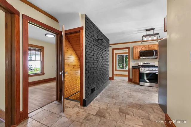 a view of a hallway with an entryway and livingroom with furniture