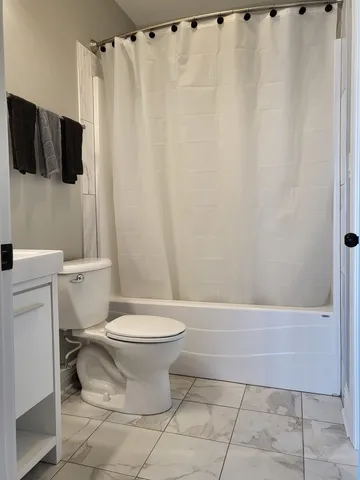 a bathroom with a toilet and a shower