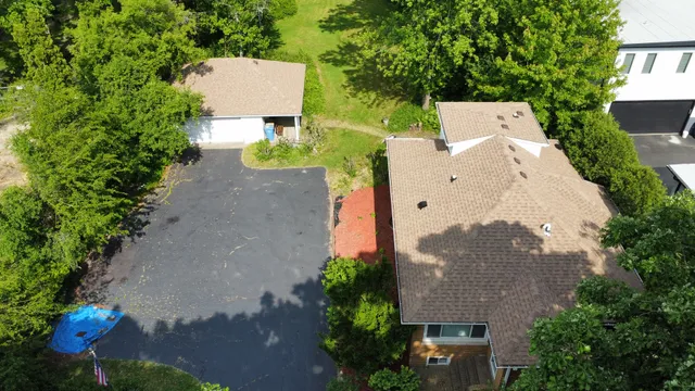 an aerial view of a house with outdoor space and a car park