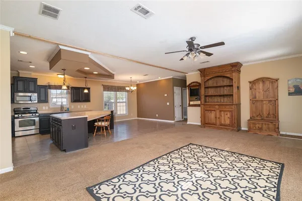 a large living room with stainless steel appliances kitchen island granite countertop furniture and a fireplace