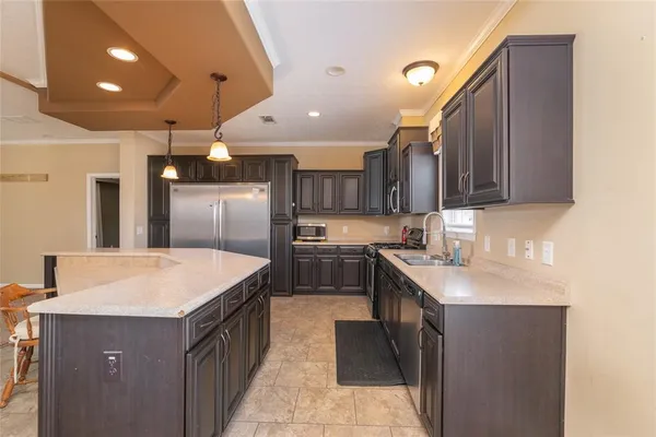 a kitchen with stainless steel appliances granite countertop a sink a stove and a refrigerator