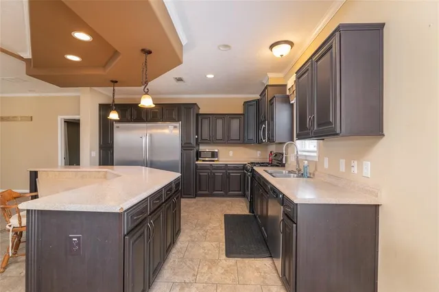 a kitchen with stainless steel appliances granite countertop a sink a stove and a refrigerator
