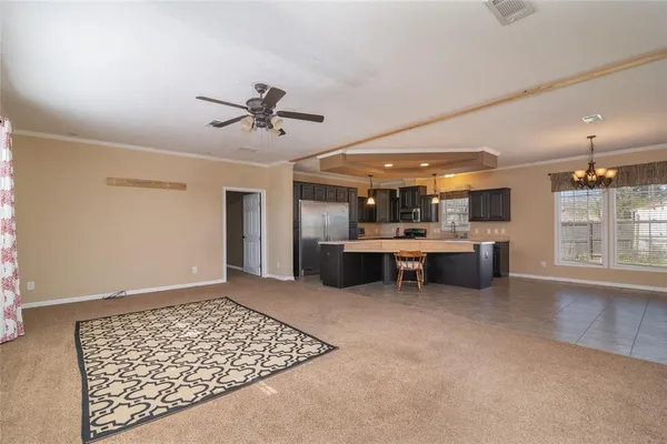a view of a livingroom with kitchen and a window