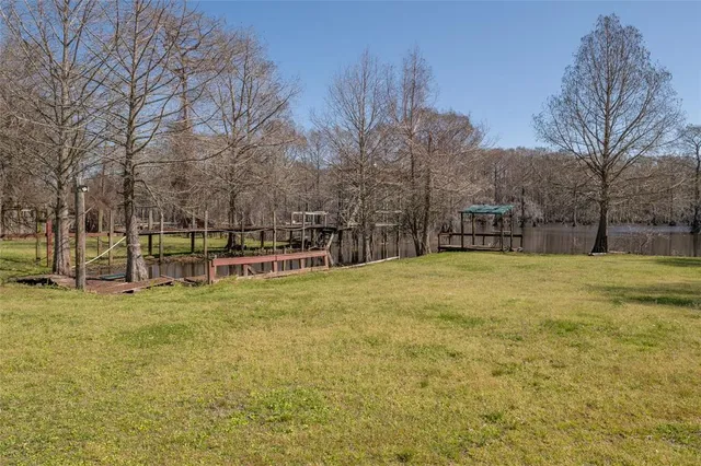 a view of yard with swimming pool and trees