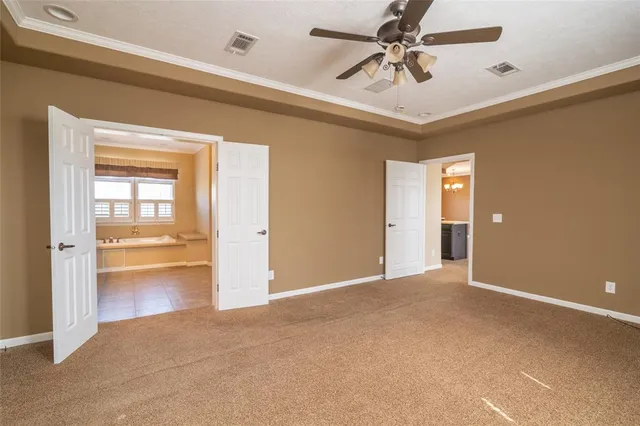 a view of an empty room and a ceiling fan