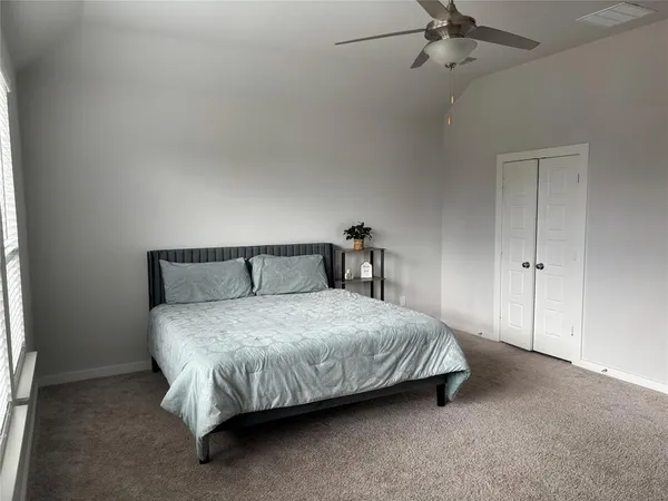 a bed sitting in a bedroom next to a window