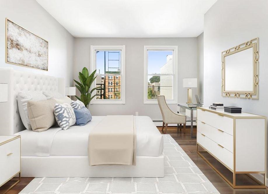 475 Palisade Avenue, Unit 4 Jersey City, NJ 07307 - Photo 1 of 16 a spacious bedroom with a large bed and a couch