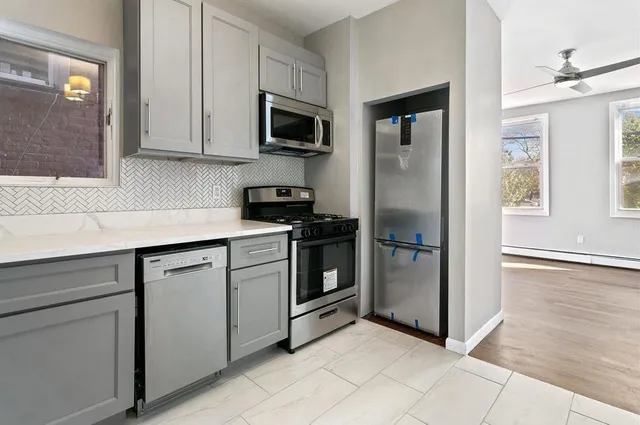 a kitchen with cabinets stainless steel appliances and window