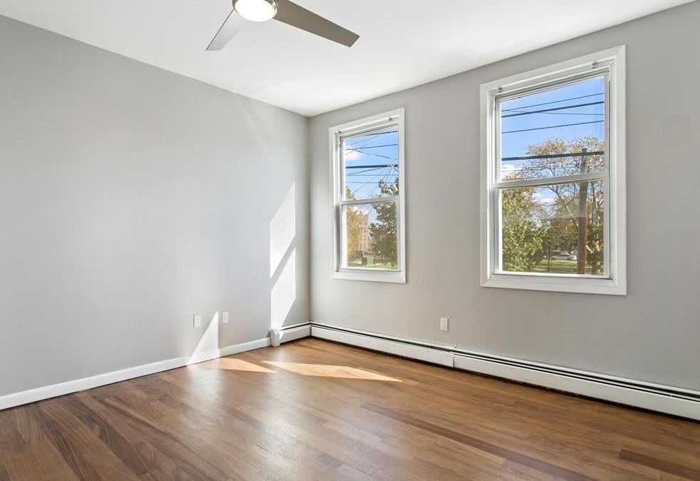 475 Palisade Avenue, Unit 4 Jersey City, NJ 07307 - Photo 5 of 16 a view of an empty room with wooden floor and a window