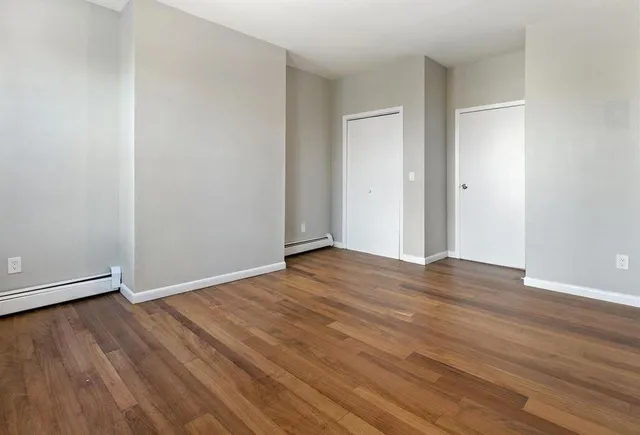 a view of an empty room with wooden floor