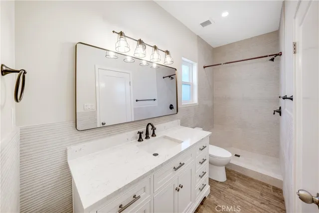 a bathroom with a double vanity sink mirror and toilet
