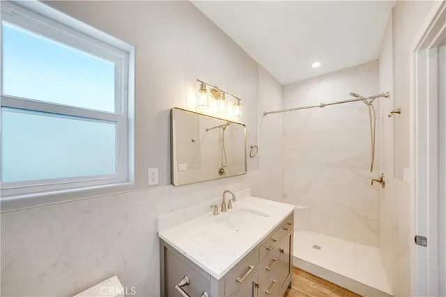 a bathroom with a sink a mirror and a shower