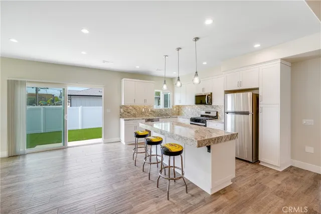a kitchen with kitchen island white cabinets and stainless steel appliances