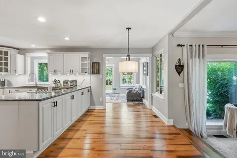 a bedroom with a bed a dresser and a chandelier