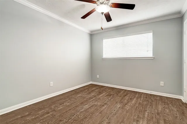 an empty room with a window and a ceiling fan