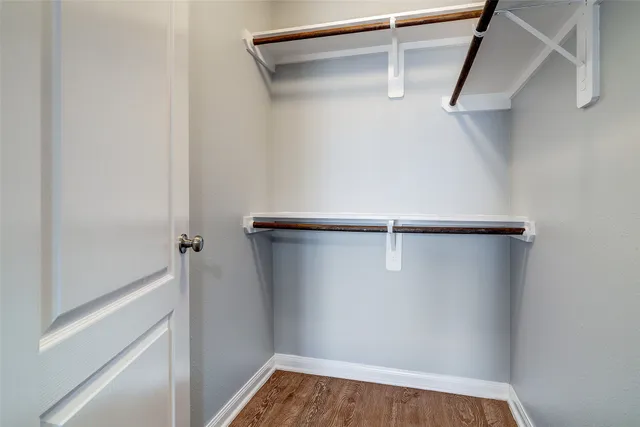 a view of walk in closet with empty racks