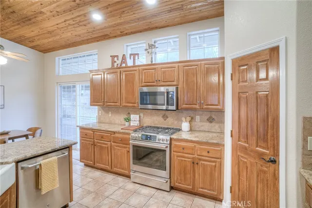 a kitchen with stainless steel appliances granite countertop a refrigerator and a stove