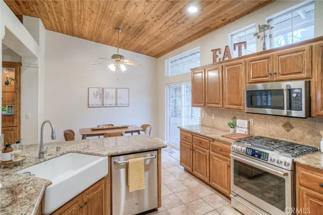 a kitchen with granite countertop a sink and refrigerator