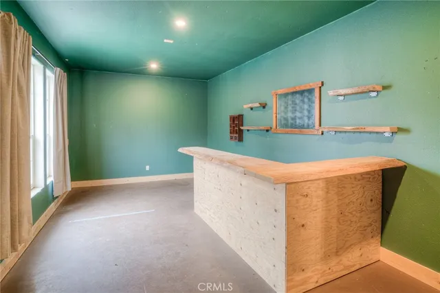 an empty room with a chandelier fan and windows