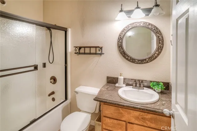 a bathroom with a tub shower vanity and sink