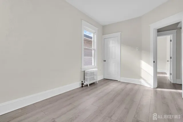 an empty room with wooden floor and a window