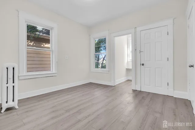 an empty room with wooden floor and window