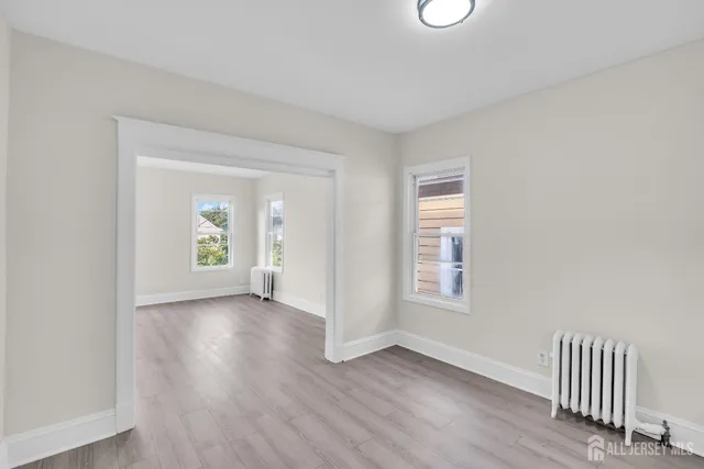 an empty room with window and wooden floor