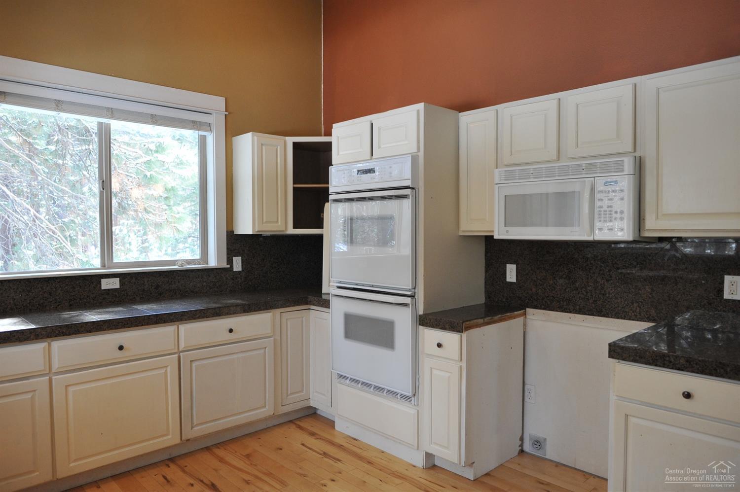 19100 Choctaw Road Bend, OR 97702 - Photo 8 of 19 a kitchen with granite countertop white cabinets and white appliances