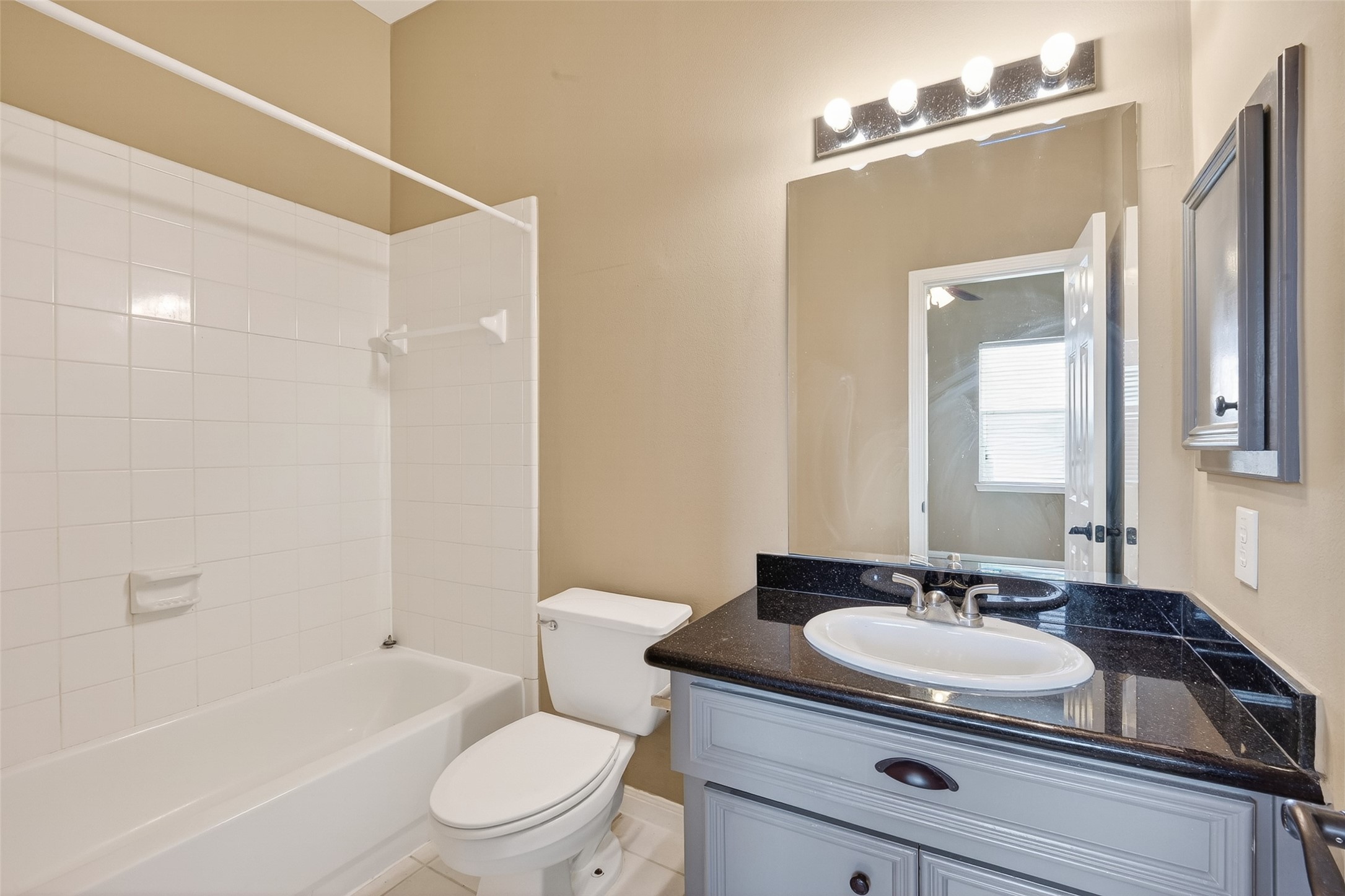 2804 Chenevert Street Houston, TX 77004 - Photo 26 of 37 a bathroom with a granite countertop sink toilet a mirror and shower