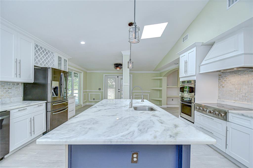 1931 Jaudon Road Dover, FL 33527 - Photo 16 of 50 a large kitchen with stainless steel appliances a large counter top a stove a sink and a refrigerator