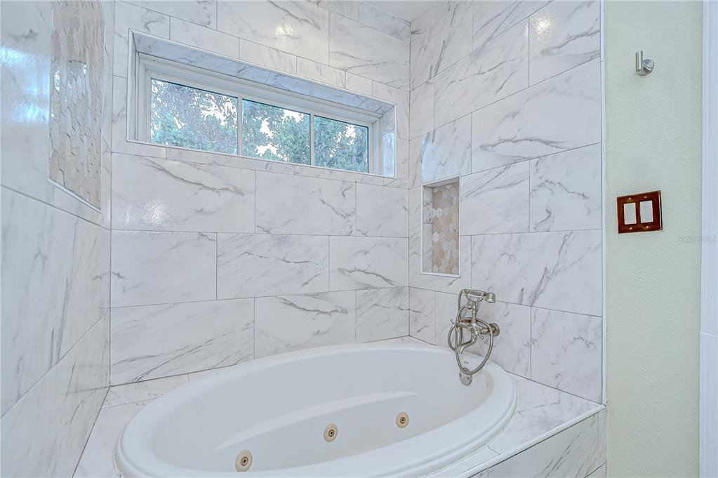 1931 Jaudon Road Dover, FL 33527 - Photo 26 of 50 a bathroom with bathtub and window