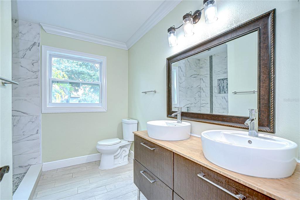 1931 Jaudon Road Dover, FL 33527 - Photo 30 of 50 a bathroom with a double vanity sink toilet and a mirror