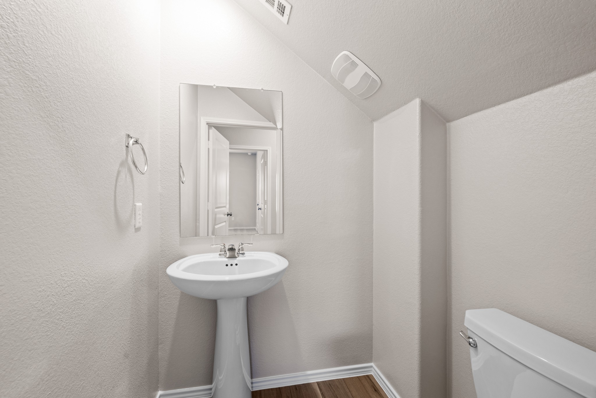 2309 Four Waters Loop Georgetown, TX 78628 - Photo 15 of 40 Half bath featuring a textured wall, dark wood finished floors, and lofted ceiling