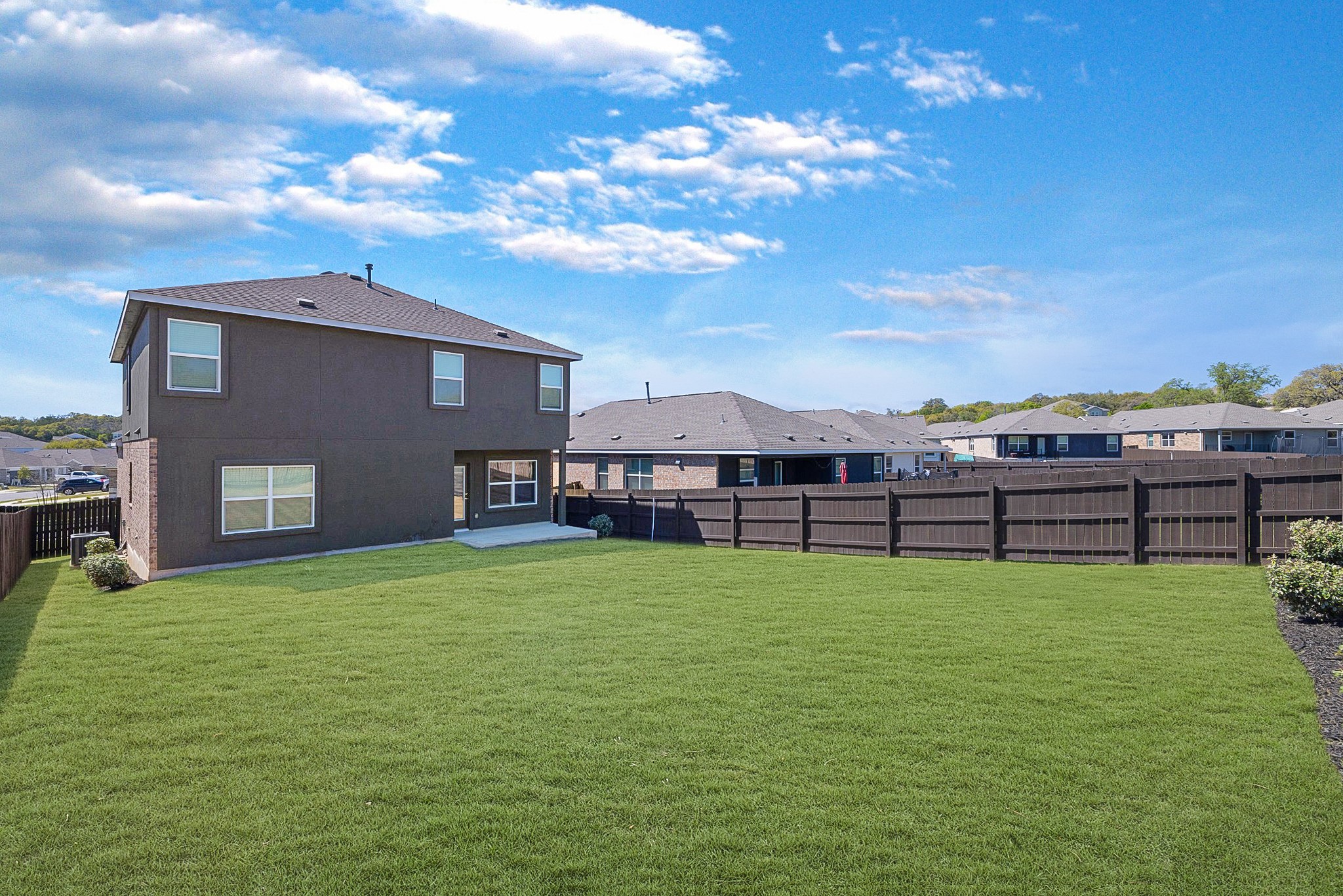 2309 Four Waters Loop Georgetown, TX 78628 - Photo 32 of 40 Back of house featuring a fenced backyard, a patio, and a residential view
