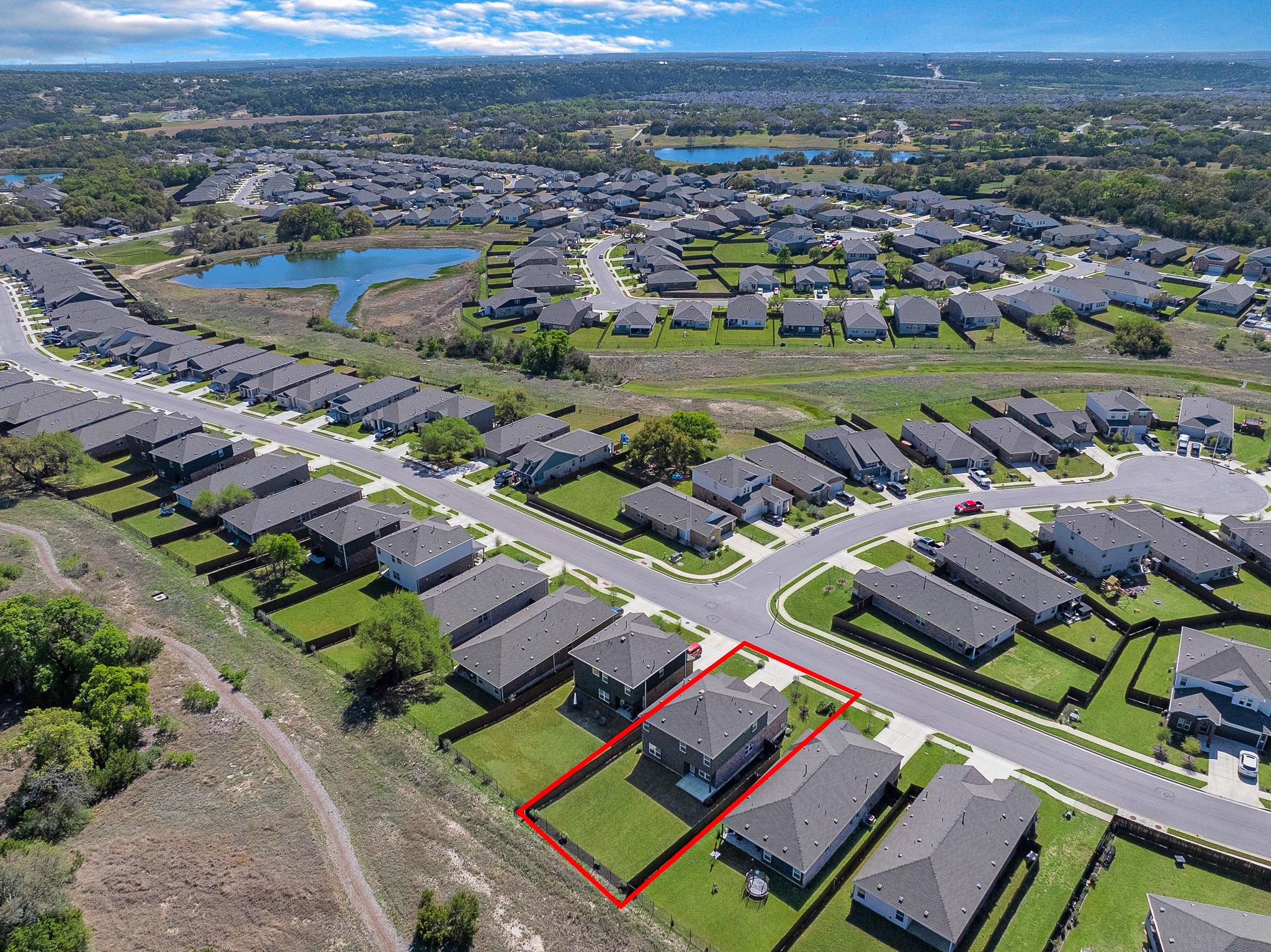 2309 Four Waters Loop Georgetown, TX 78628 - Photo 37 of 40 Aerial perspective of suburban area with property parcel outlined and a large body of water