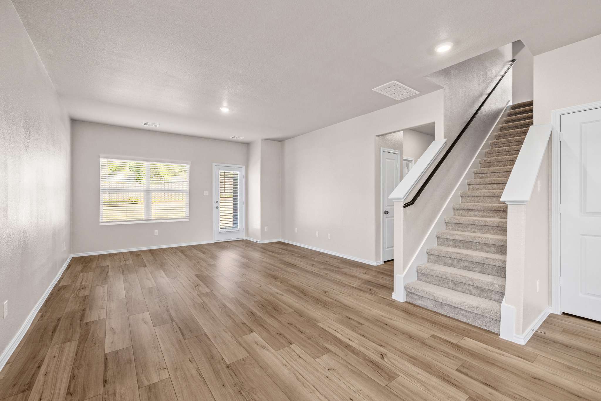 2309 Four Waters Loop Georgetown, TX 78628 - Photo 9 of 40 Unfurnished living room featuring light wood-style floors and recessed lighting