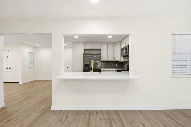 a view of kitchen with stainless steel appliances refrigerator sink and cabinets