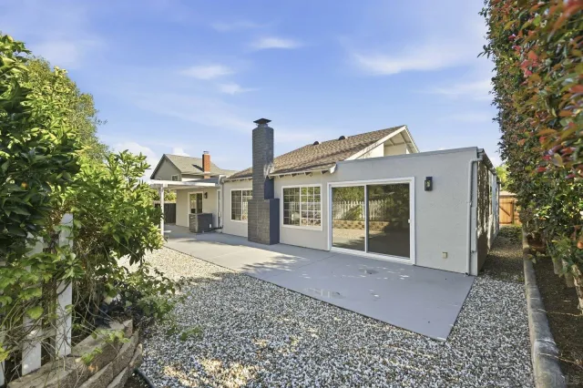 a front view of a house with a yard and potted plants