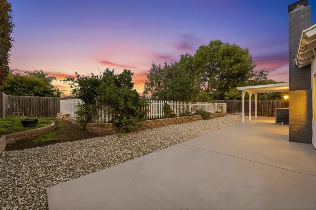 a view of a house with backyard and trees