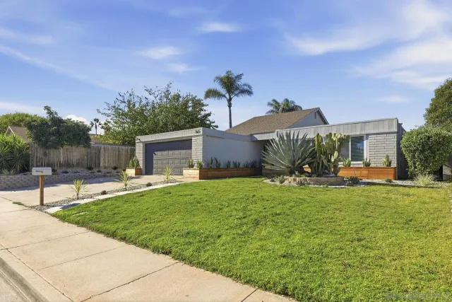 a view of a house with backyard and sitting area