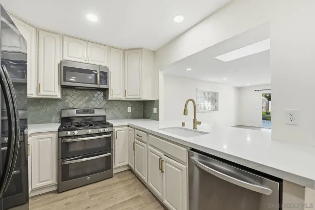 a kitchen with sink a microwave and cabinets