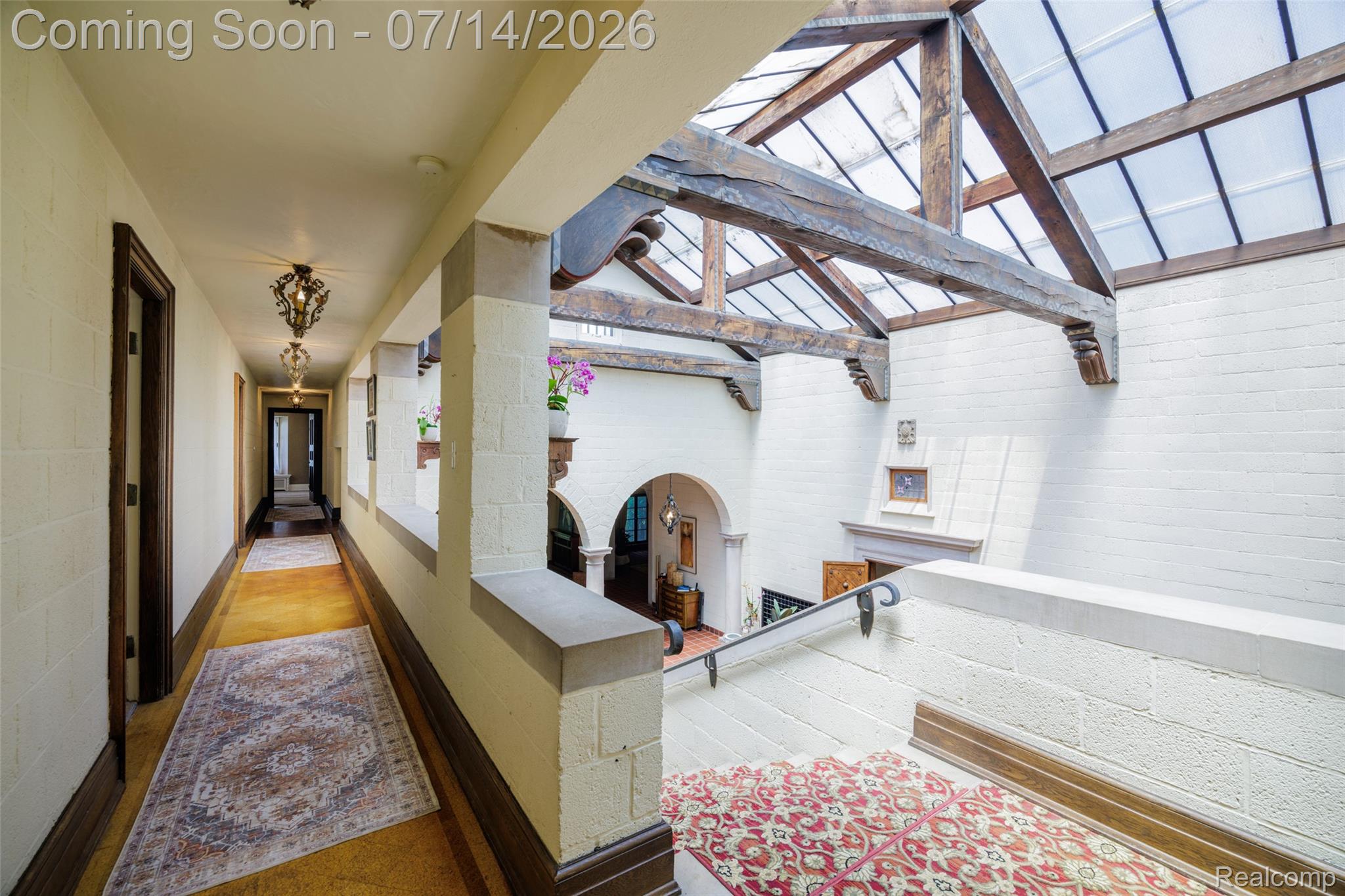 189 Cloverly Road Grosse Pointe, MI 48236 - Photo 40 of 96 Grand atrium featuring a skylight with exposed wood beams, white painted brick walls, and decorative sconces