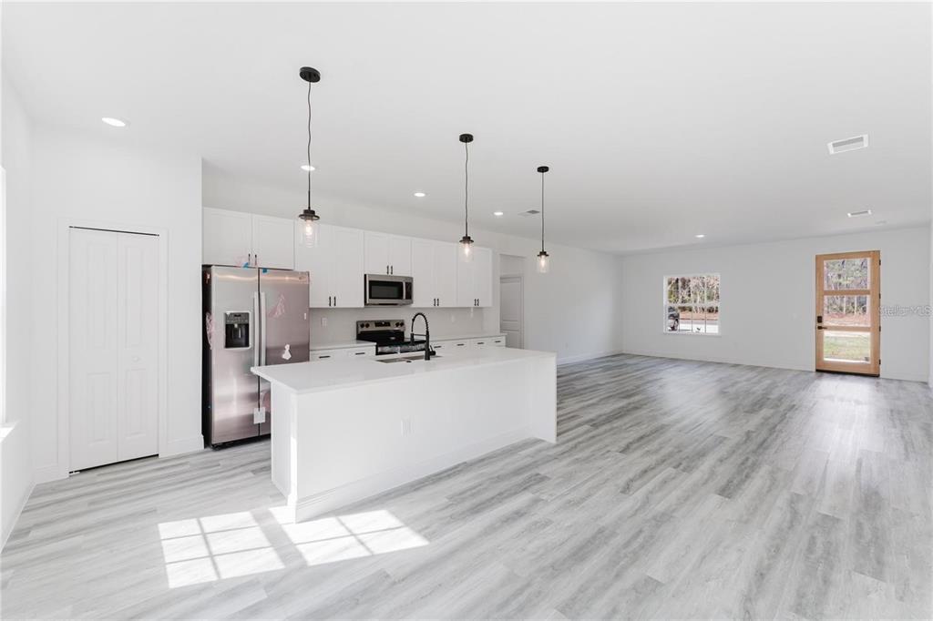 6732 Southwest 132nd Street Ocala, FL 34473 - Photo 12 of 36 a living room with stainless steel appliances kitchen island hardwood floor and a view of kitchen
