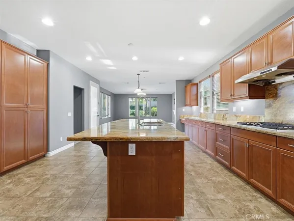 a kitchen with granite countertop stainless steel appliances wooden cabinets and a sink