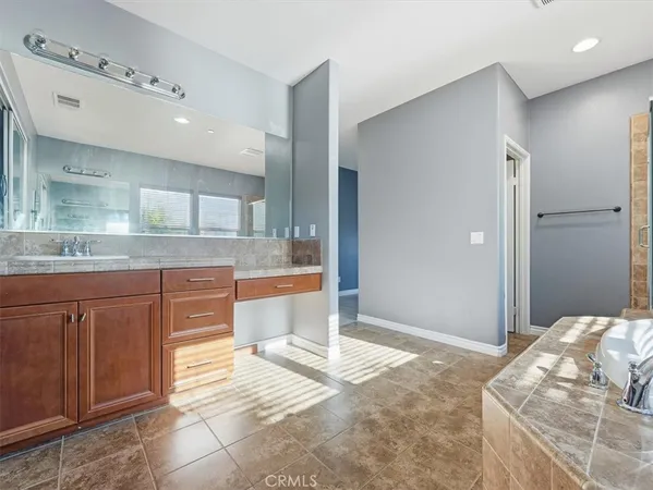 a bathroom with a tub a sink and mirror