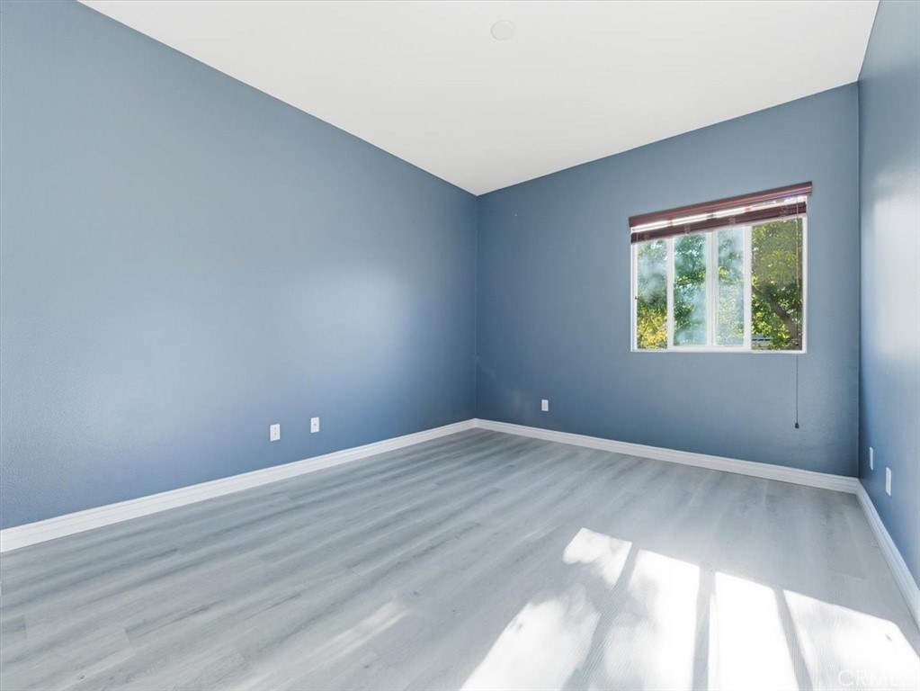 2947 Gilbert Avenue Corona, CA 92881 - Photo 33 of 60 a view of an empty room with wooden floor and a window